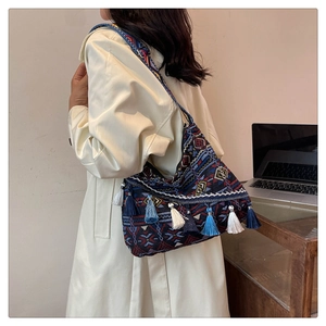Detail of bohemian shoulder bag featuring geometric jacquard fabric and colorful tassels