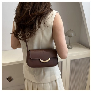 Close-up of vintage brown PU leather shoulder bag with a gold crescent metal buckle