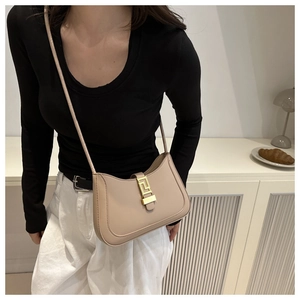 Détail du sac croissant élégant avec texture beige et boucle métallique dorée chic