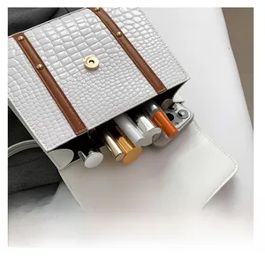 Detalle del compartimento de bolso blanco con relieve de cocodrilo y cosméticos