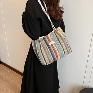 Détail du sac cabas tissé à rayures colorées avec bandoulière blanche et étiquette