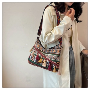 Bohemian jacquard shoulder bag with ethnic patterns and colorful tassels on a beige coat