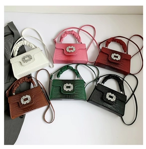 Flat lay of stylish crocodile embossed handbags with rhinestone buckles in six colors