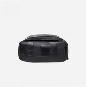 Detailed bottom view of the black leather backpack featuring patchwork design and texture