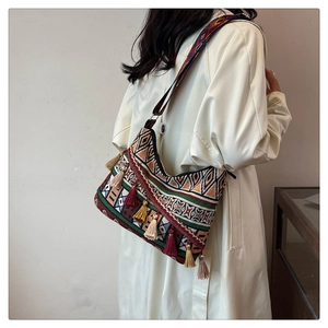 Detail of bohemian shoulder bag featuring colorful tassels and woven geometric patterns