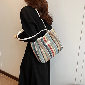 Détail du sac cabas tissé à rayures colorées avec anses en corde blanche et étiquette