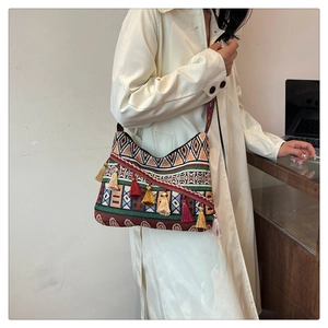 Ethnic style woven shoulder bag detail with colorful tassels and geometric patterns