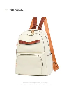 Detail of white Oxford fabric backpack with brown straps and golden metal zippers