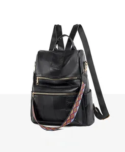 Detail of black patchwork leather backpack with colorful geometric strap and gold zippers