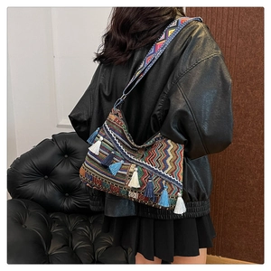 Detail view of ethnic crossbody bag with colorful weaving and blue-white tassels