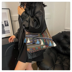 Close-up of bohemian woven bag with ethnic geometric patterns and stylish blue tassels