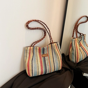 Gros plan du sac cabas tissé coloré avec étiquette en cuir et poignée tressée