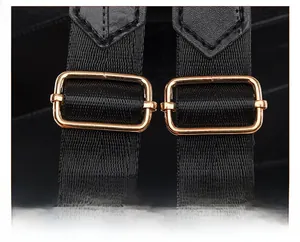 Detail of adjustable black nylon shoulder strap with polished gold rectangular buckle