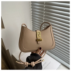 Detail van beige halvemaanvormige tas met gouden gesp en luxe lederen textuur