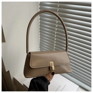 Detailed close-up of dark beige baguette bag with elegant gold metal twist lock