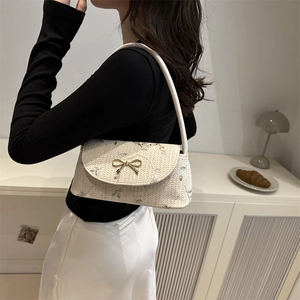 Chic cream woven baguette bag with floral embroidery and gold bow buckle in life scene