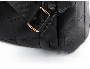Close-up of triangle-reinforced stitching on leather backpack strap with gold hardware
