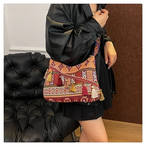 Close-up of bohemian shoulder bag featuring colorful geometric patterns and long tassels