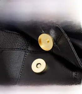 Vue détaillée du fermoir magnétique doré et cuir grainé sur le sac à dos femme