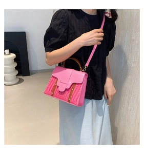 Detail of pink crossbody bag featuring croc-embossed texture and contrast brown straps