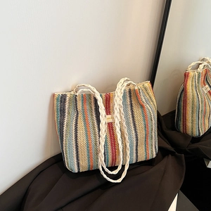 Détail du sac cabas tissé à rayures colorées avec poignées en corde blanche et étiquette