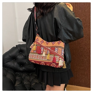 Close-up of bohemian messenger bag with colorful jacquard patterns and tassels