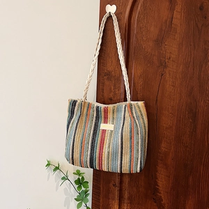 Détail du sac cabas tissé coloré avec rayures verticales et poignées tressées