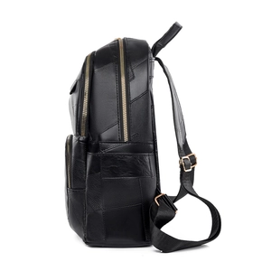Black patchwork leather backpack with gold zippers and adjustable straps on white background