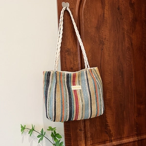 Gros plan du sac fourre-tout tissé à rayures colorées avec anses en corde et crochets cœur