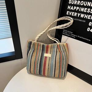 Détail d'un grand sac cabas en paille tissée à rayures colorées et étiquette mode