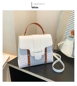 Detail of white and blue faux crocodile leather crossbody bag with brown handle decoration