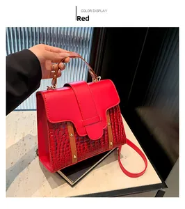 Detail of red PU leather handbag with crocodile pattern splicing and gold rivets