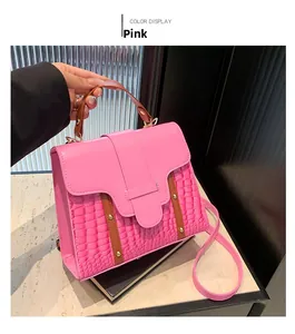 Pink minimalist crossbody bag with brown handle and crocodile texture leather detail
