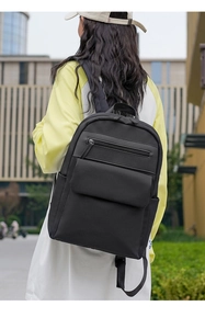 Outdoor urban shot of a black Oxford backpack featuring a multi-pocket design and adjustable straps