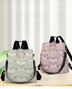 Detail of floral printed backpacks with golden bow charms and black woven straps