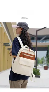Outdoor shot of stylish beige and brown oxford backpack worn by a model on a city street