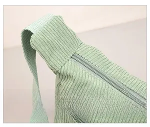 Detail shot of mint green corduroy crossbody bag showing reinforced strap stitching and zipper