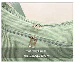 Detail shot of the durable double zippers and corduroy texture on the light green bag