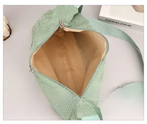 Detail view of mint green corduroy bag interior with khaki lining and silver zipper