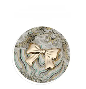 Close-up of golden bow metal clasp and intricate floral jacquard texture on backpack