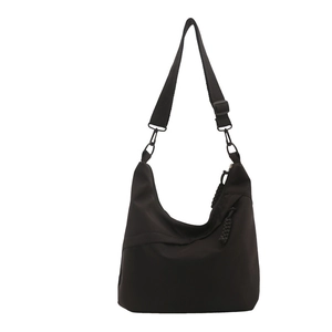Modern black nylon tote bag with wide strap and braided zip puller on white background