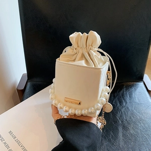 Sac seau blanc élégant avec poignée en perles, chaîne dorée et fermeture à cordon