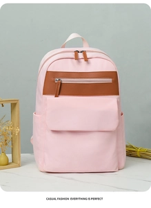 Detail view of pink oxford backpack with stylish leather zippers on white marble table