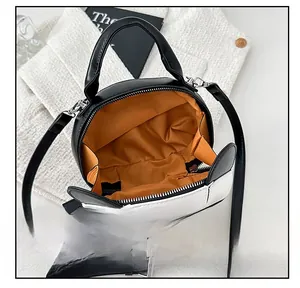Détail de la doublure orange et de l'ouverture zippée du sac panda bicolore