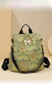 Detail of vintage floral jacquard fabric and golden bow metal buckle on backpack