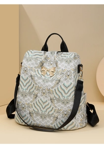Detailed view of the vintage floral fabric and gold bow buckle on the women's backpack