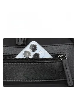 Detailed view of black oxford fabric front zipper pocket with a smartphone inside