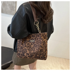 Detailed leopard print texture on large tote bag with brown leather handles and gold chain