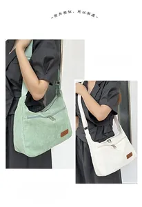 Detail of corduroy shoulder bag showing wide strap and dark leather brand tag