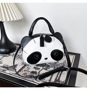 Détail du sac panda en cuir synthétique avec accents métalliques sur les yeux et la bandoulière